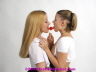 Two teen girls licking the same lollipop